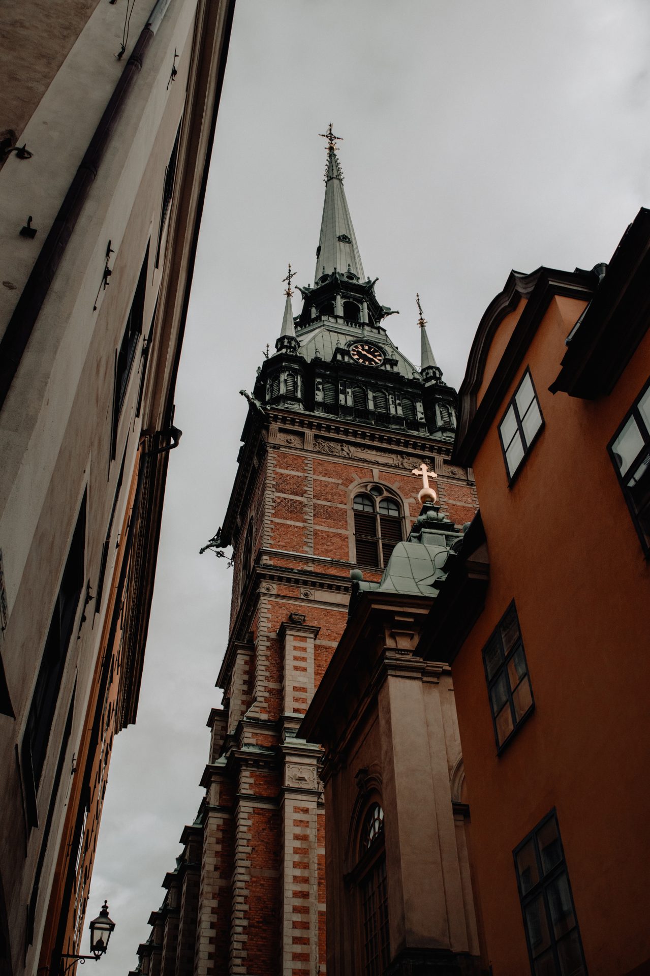 A brick church tower framed by a narrow Stockholm street