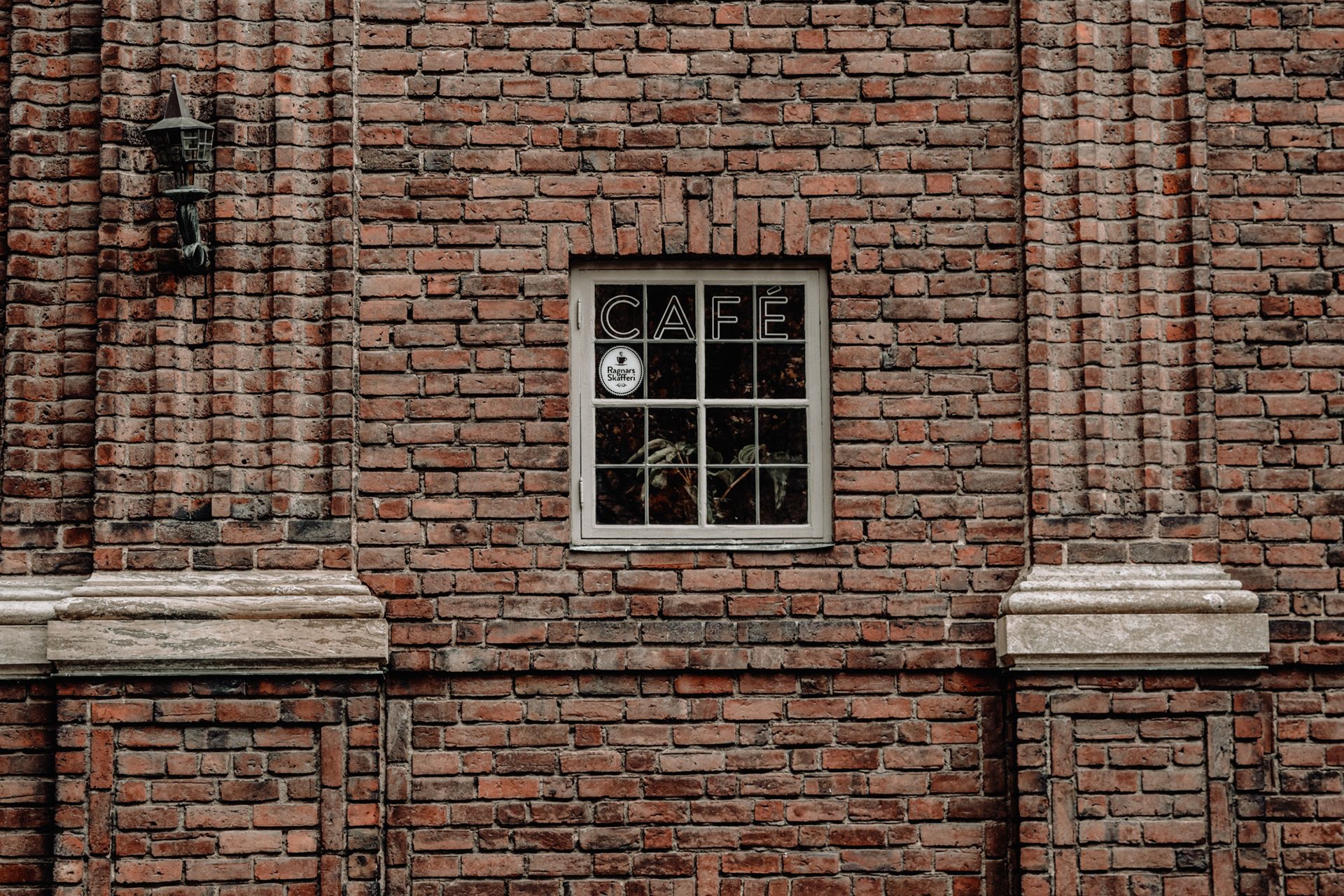 Small café window set into an old brick wall, Stockholm